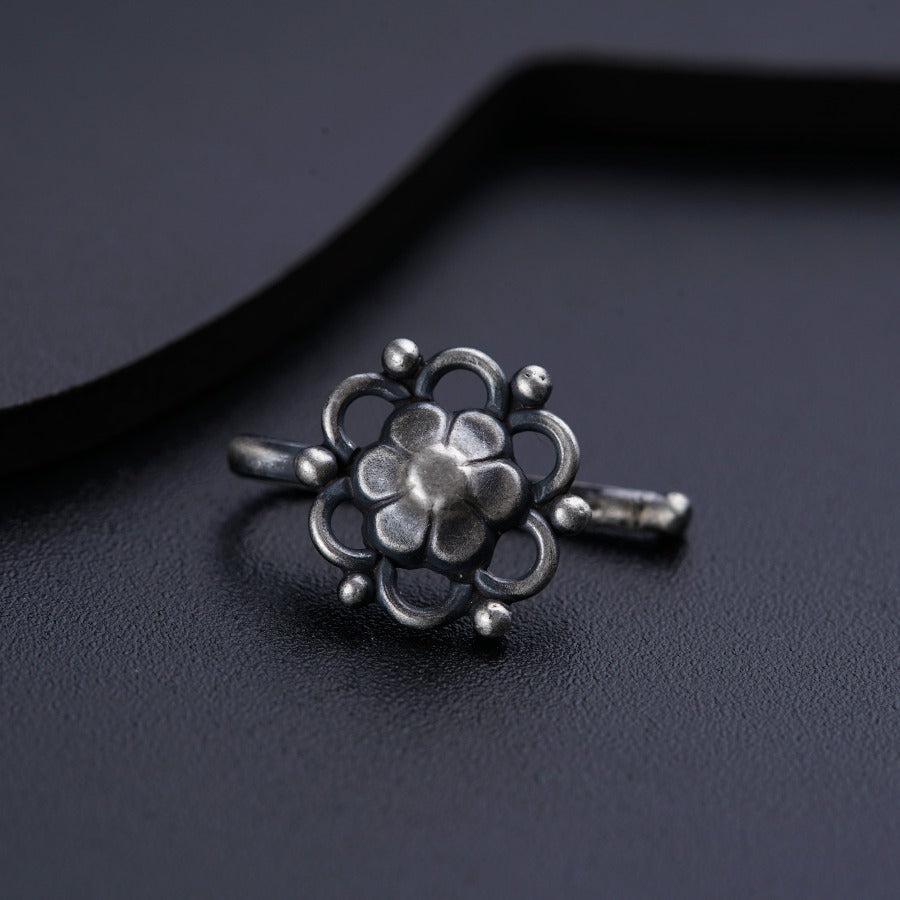 a silver ring sitting on top of a black surface