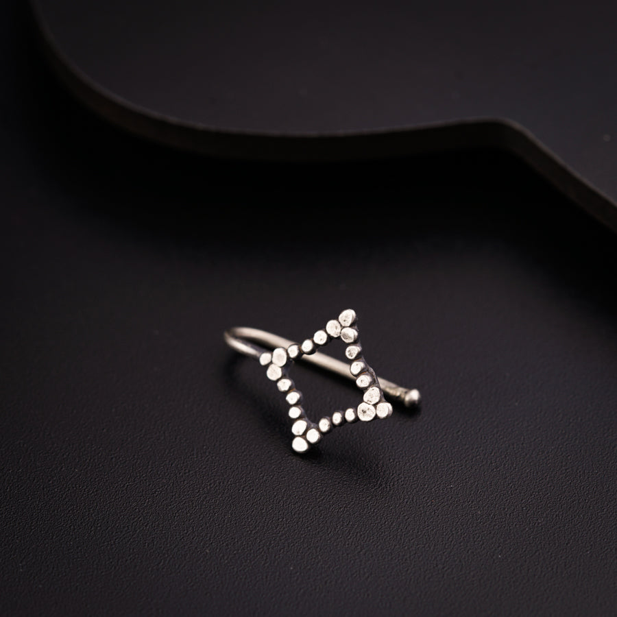 a silver ring sitting on top of a black surface