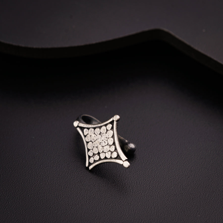 a silver ring sitting on top of a black surface