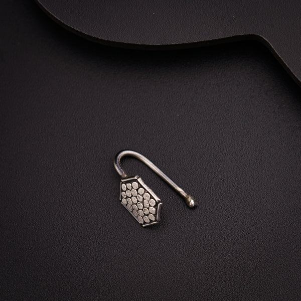 a pair of earrings sitting on top of a black surface