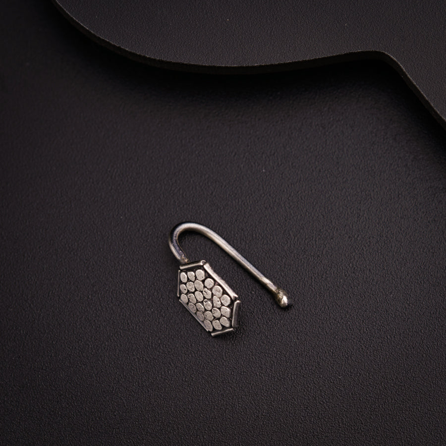 a pair of earrings sitting on top of a black surface