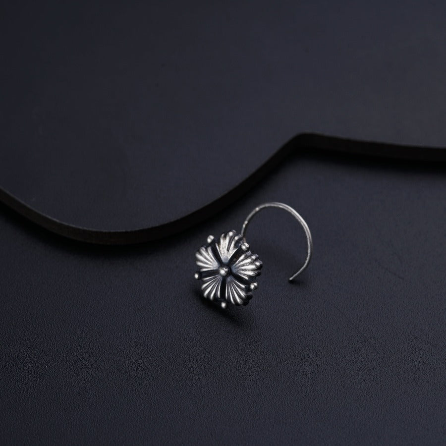 a pair of earrings sitting on top of a black surface