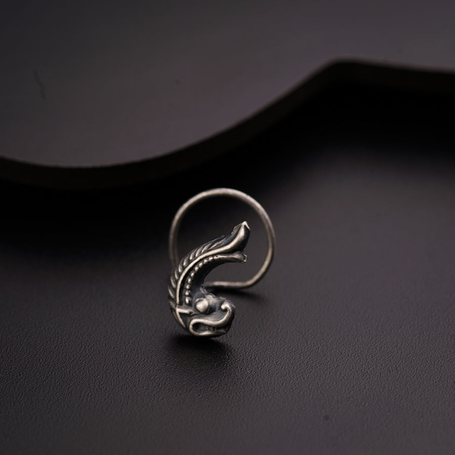 a close up of a silver ring on a black surface