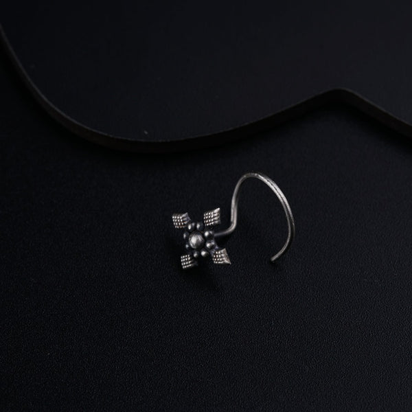 a pair of earrings sitting on top of a black surface