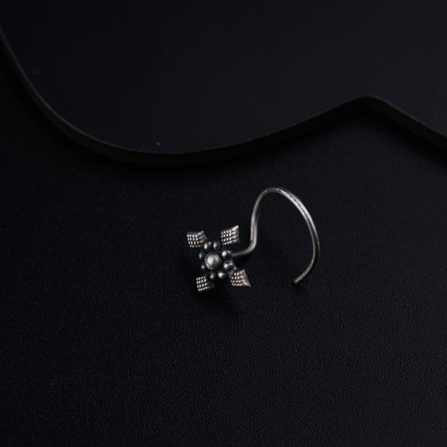a pair of earrings sitting on top of a black surface