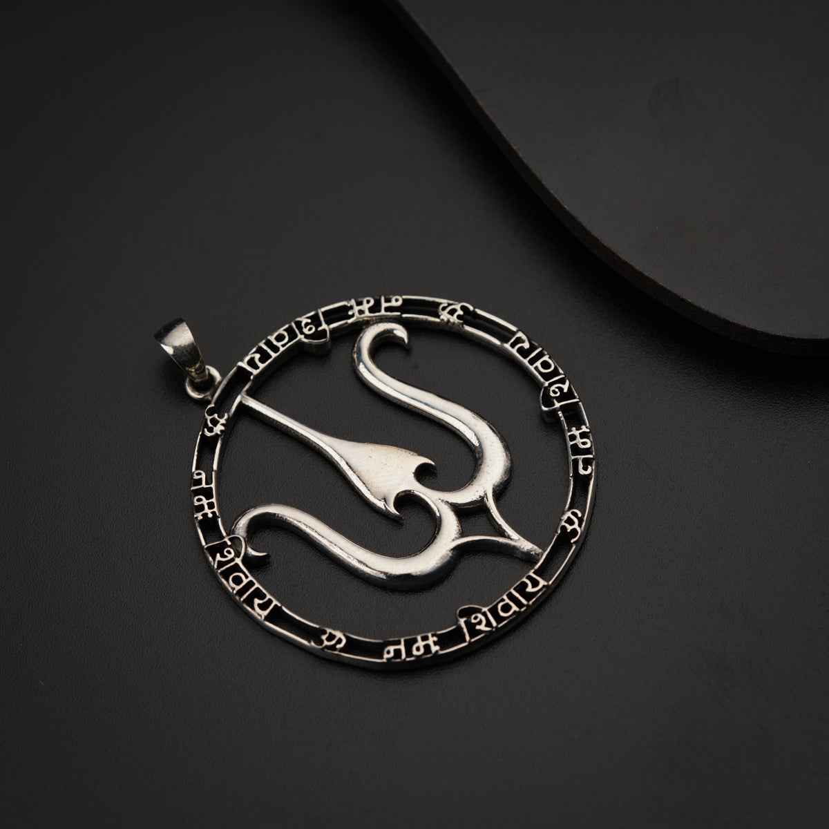 a silver pendant with the letter s in a circle