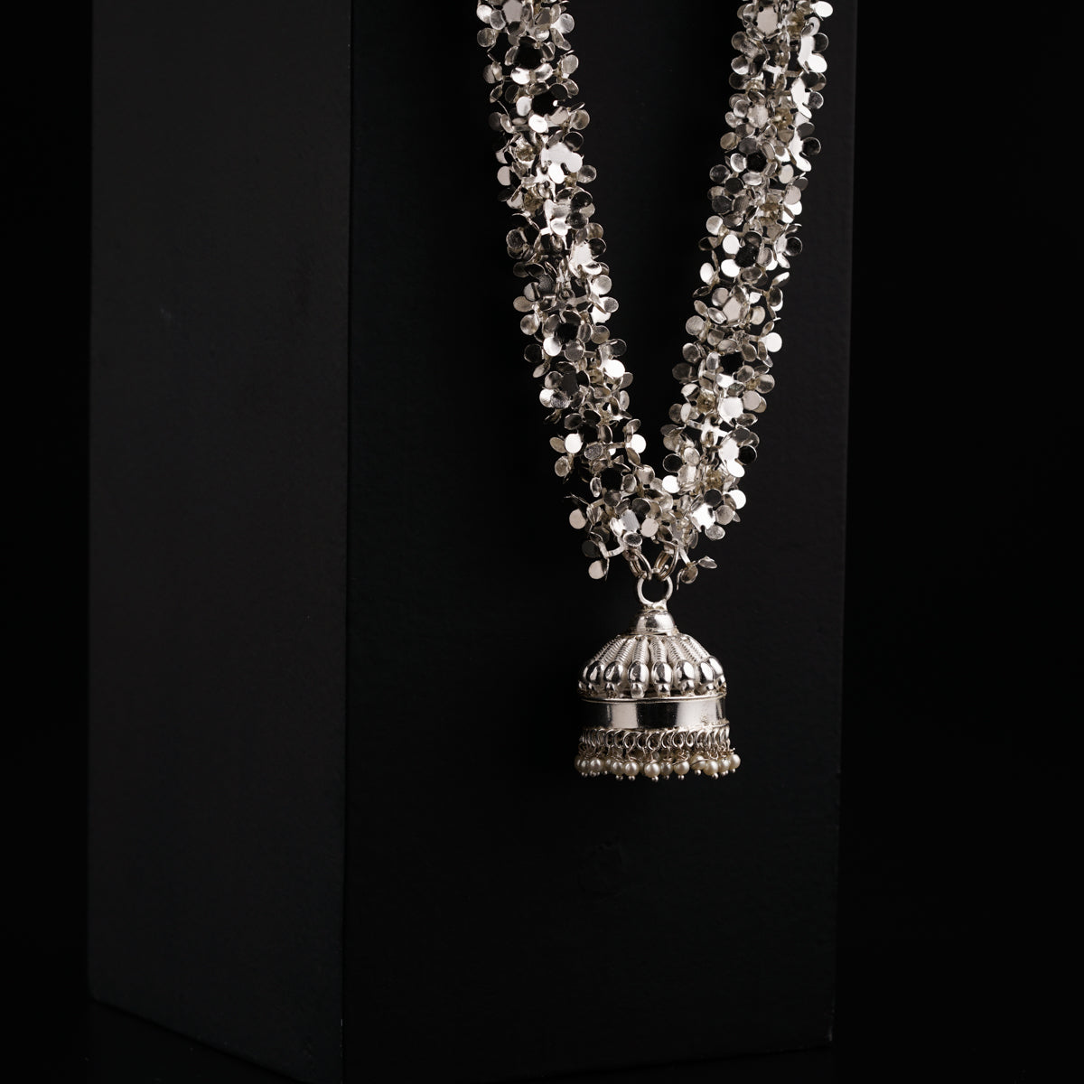 a necklace with a bell hanging from it