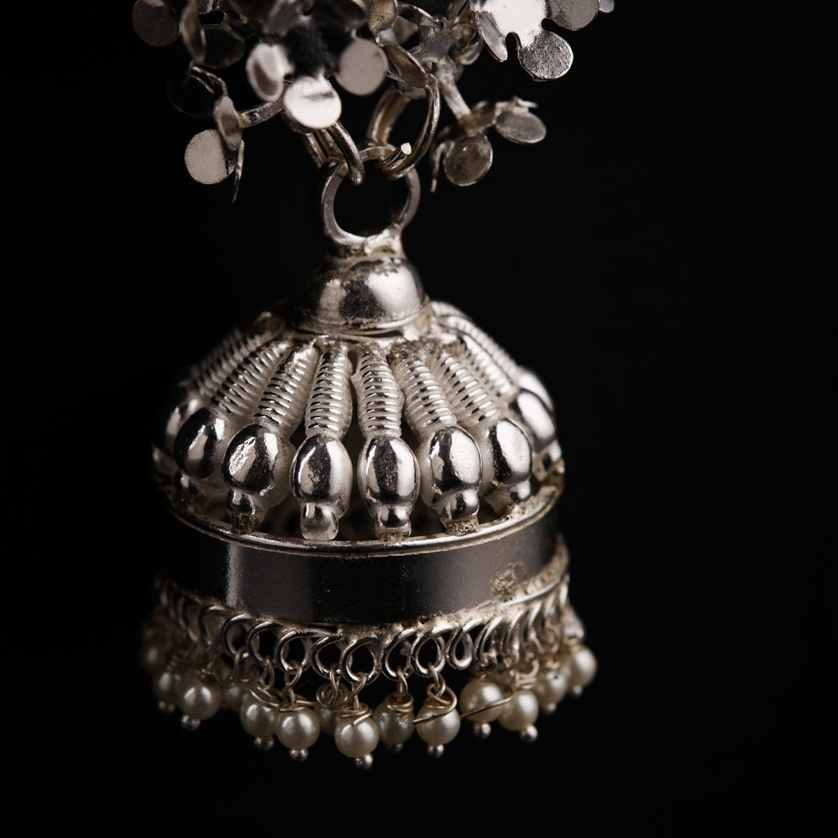 a silver vase filled with lots of silver beads