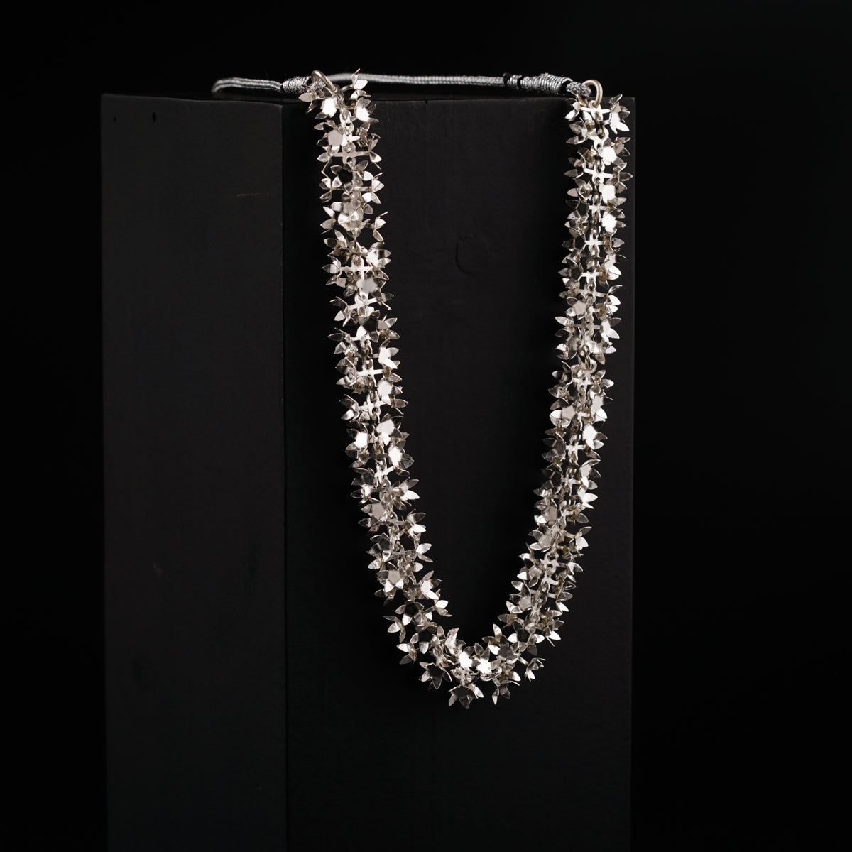 a necklace is displayed on a black background