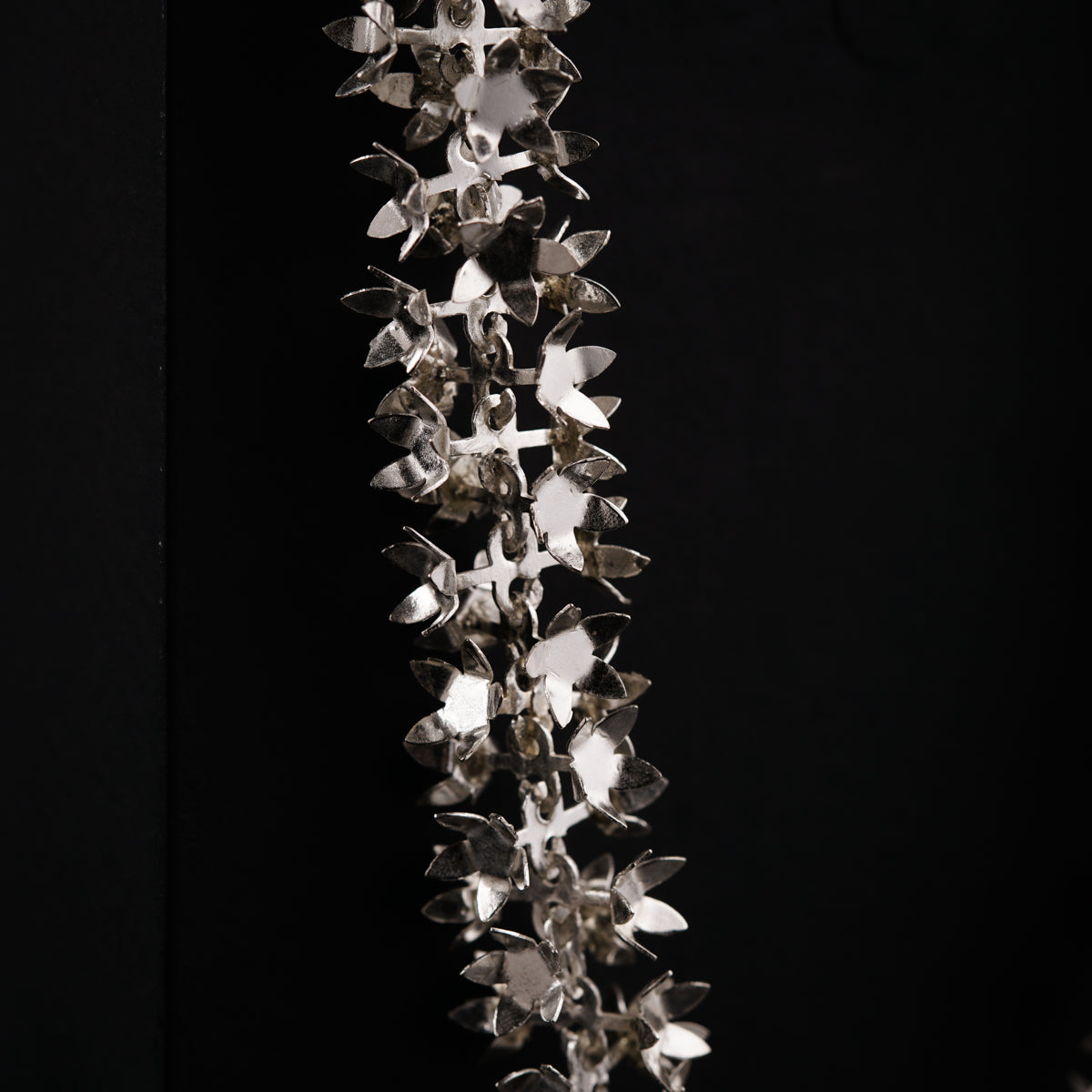 a metal object hanging from a black wall
