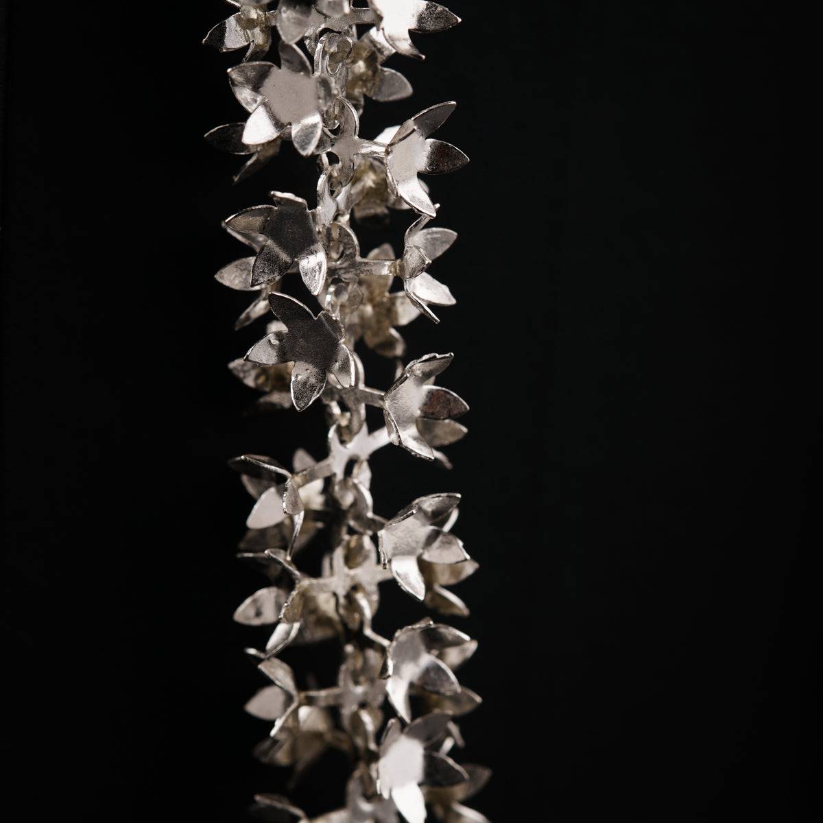 a bunch of silver flowers on a black background