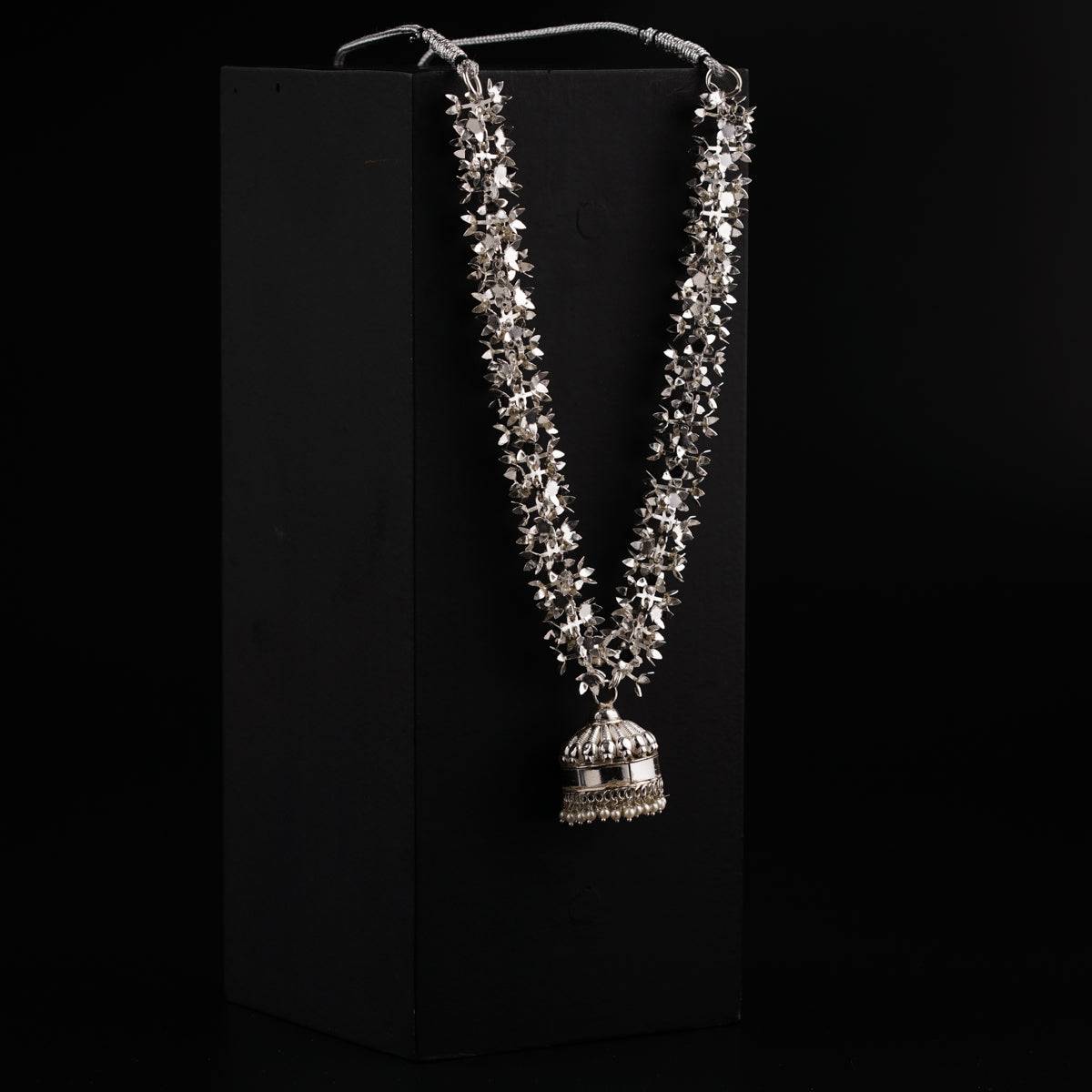 a necklace with a bell hanging from it