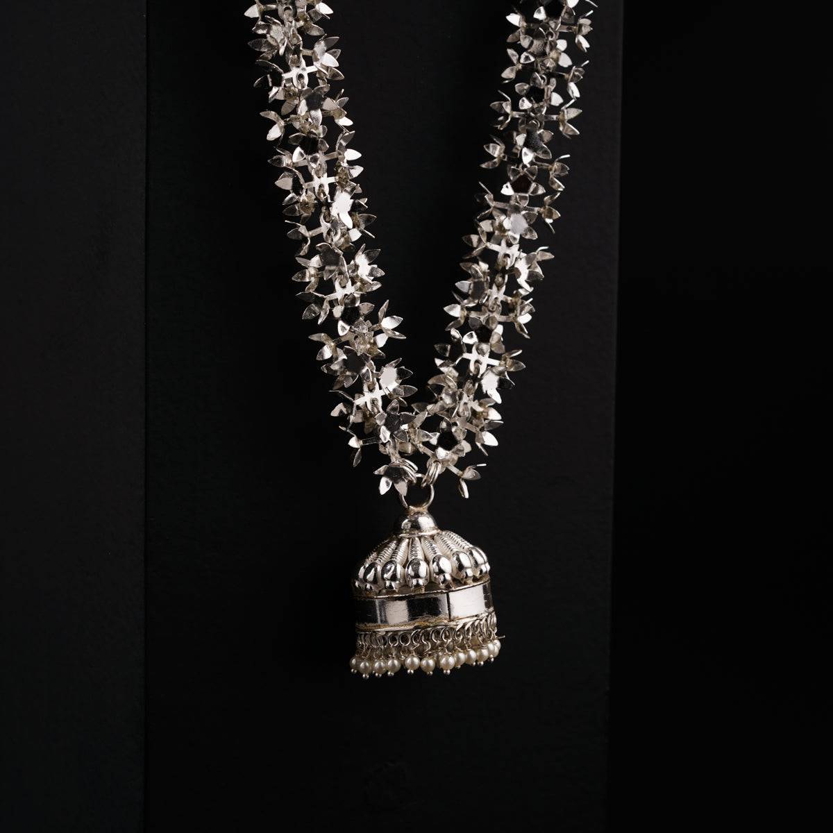 a necklace with a bell hanging from it