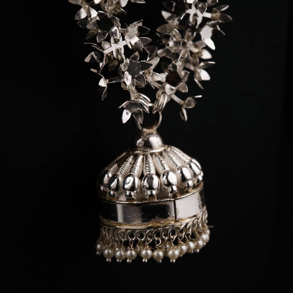 a silver vase filled with lots of silver flowers