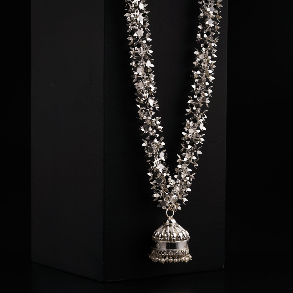 a necklace with a bell hanging from it