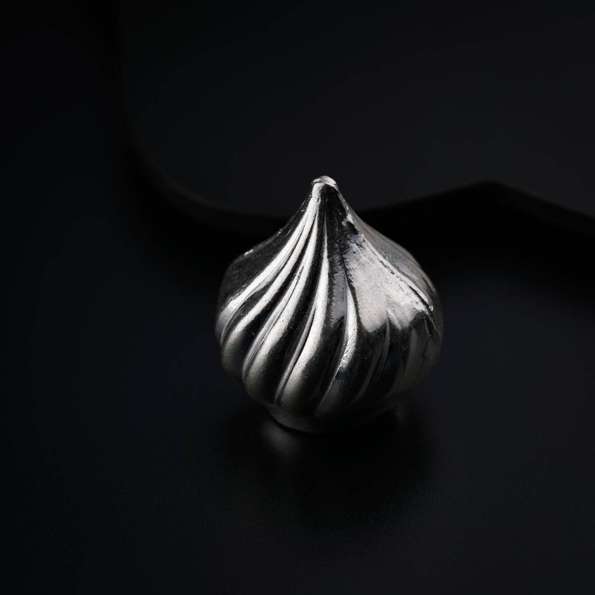 a silver ring sitting on top of a black surface