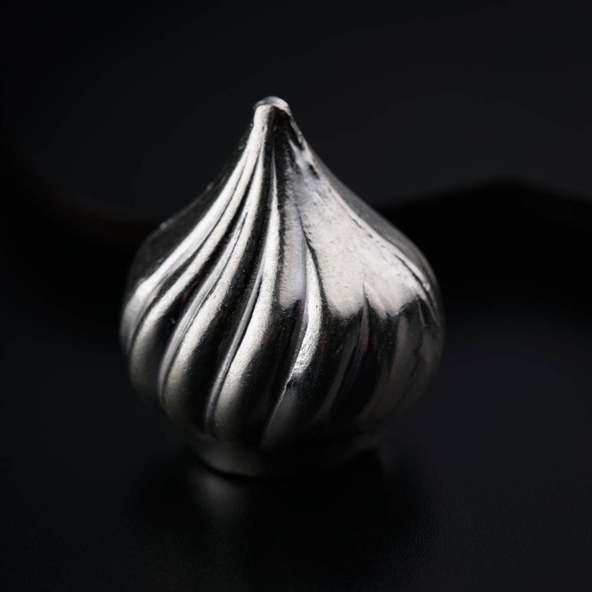 a close up of a metal object on a black surface