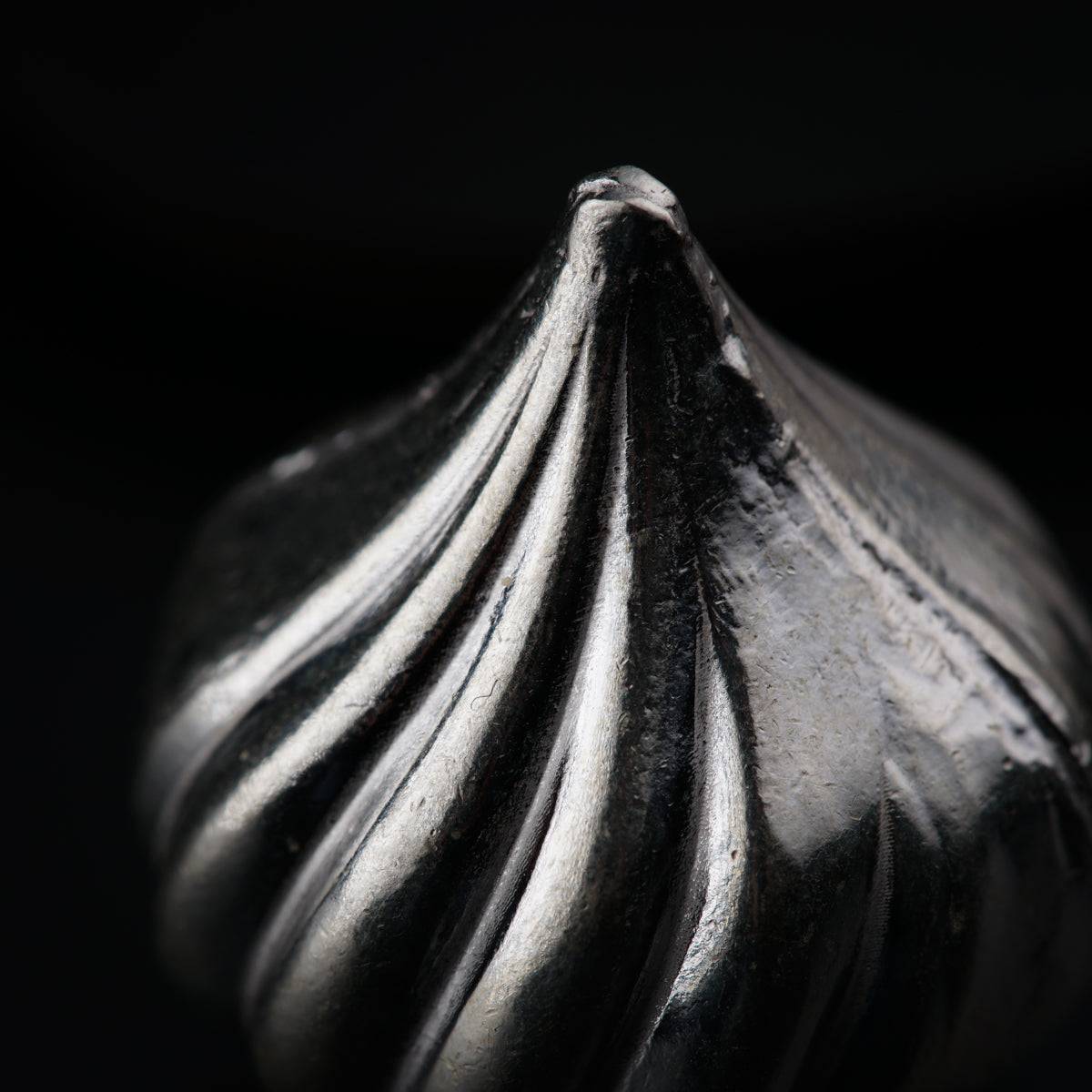 a close up of a metal object on a black background
