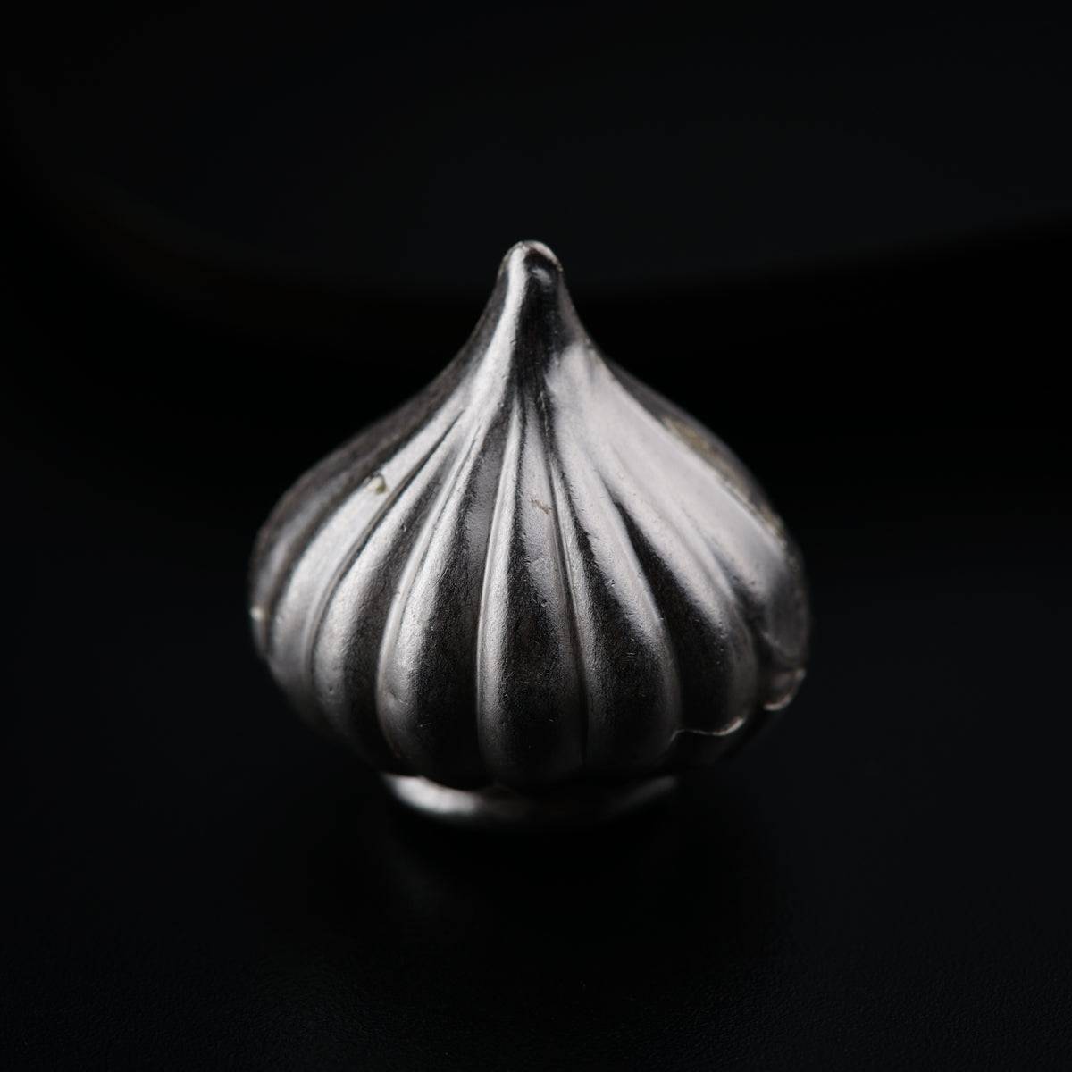 a close up of a metal object on a black surface