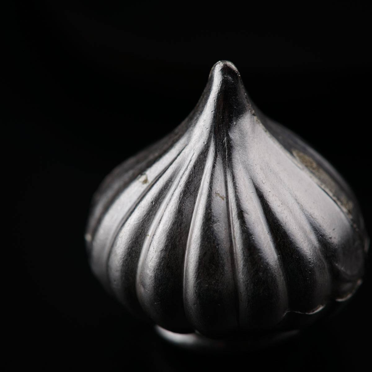 a close up of a metal object on a black background