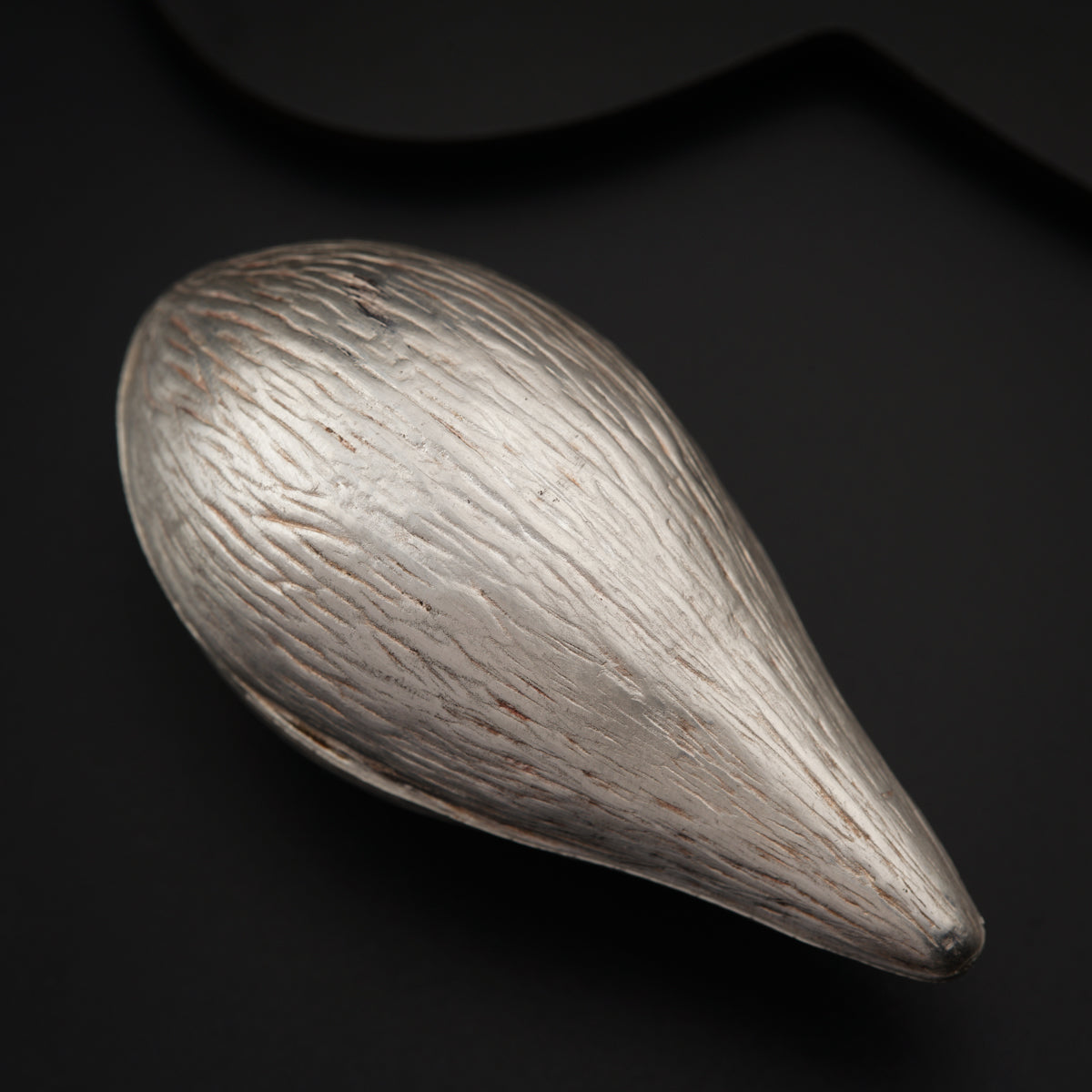 a close up of a metal object on a black surface