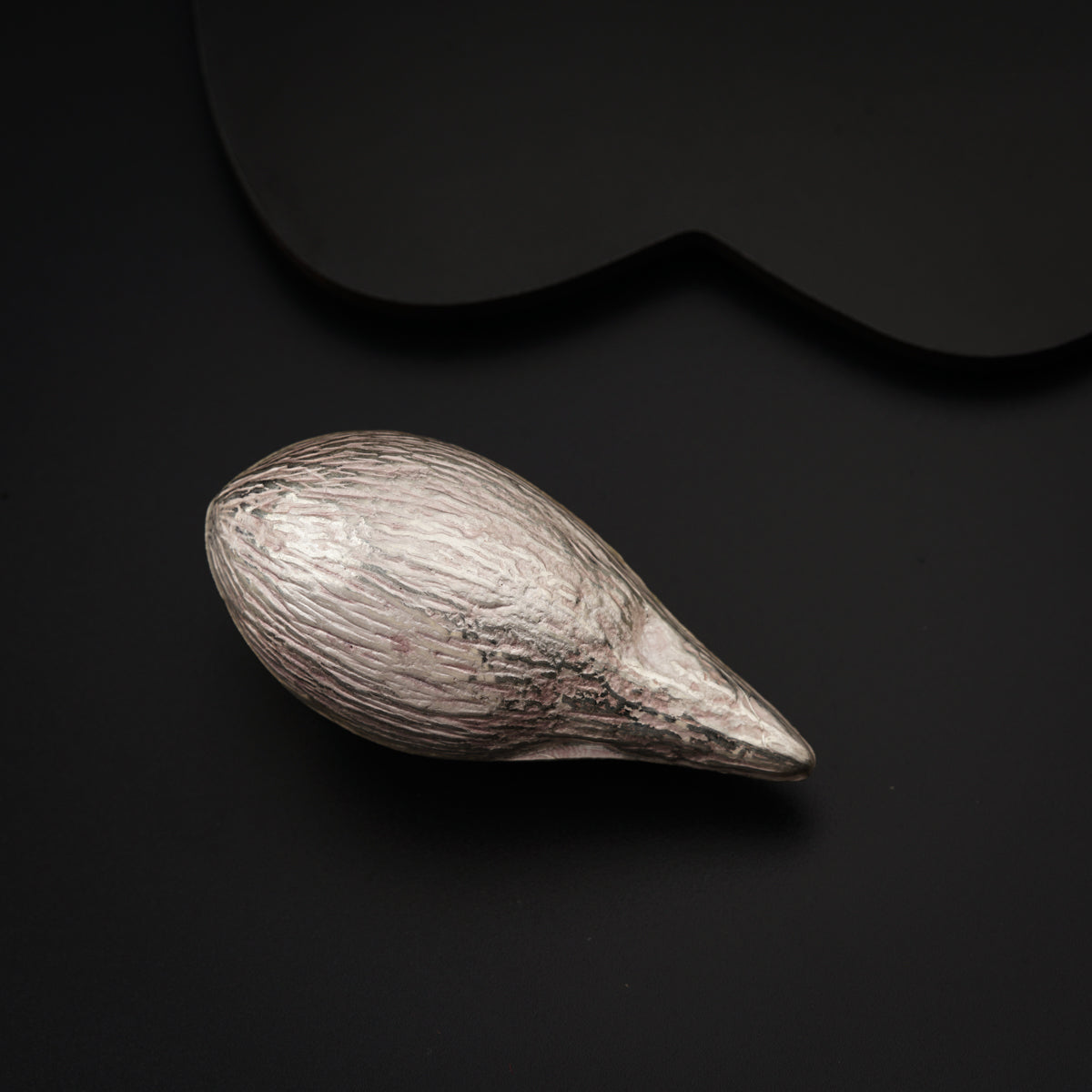 a close up of a metal object on a black surface