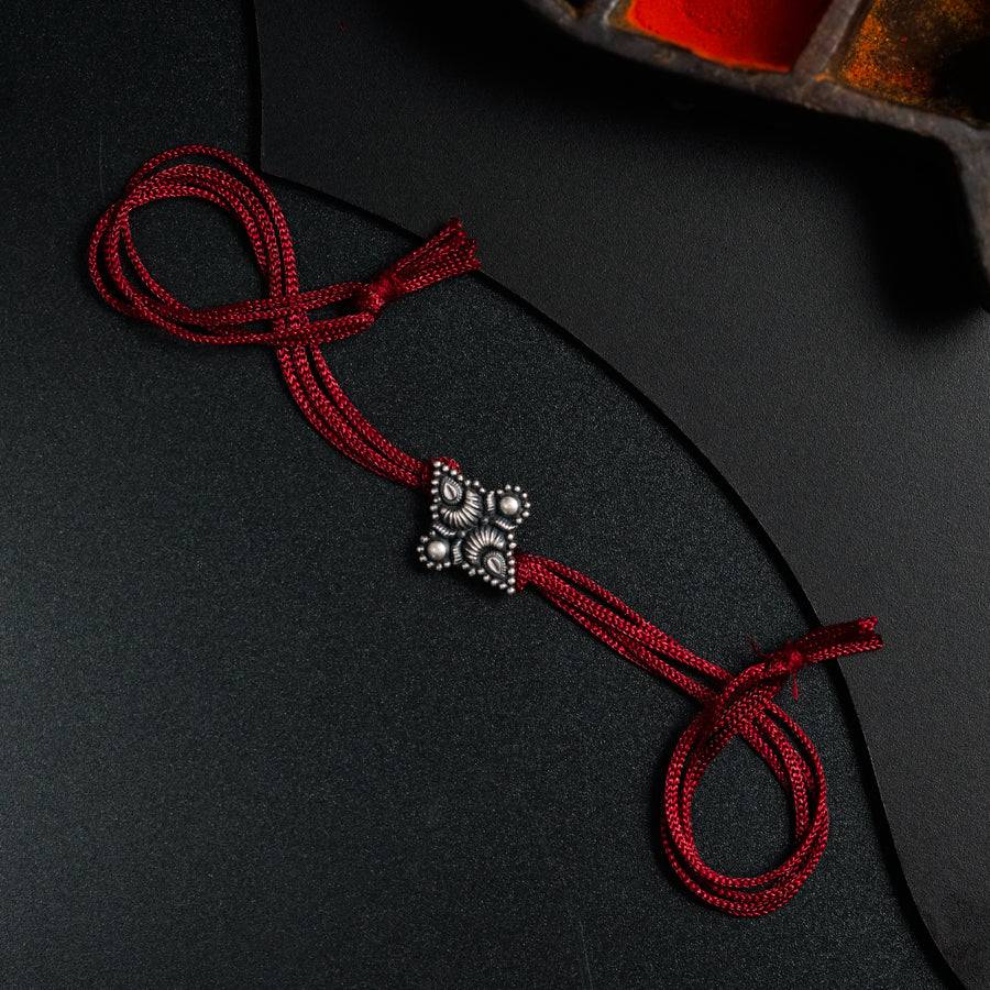 a red string with a cross on it