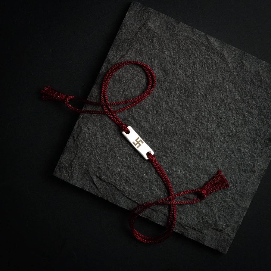 a piece of paper with a red string attached to it