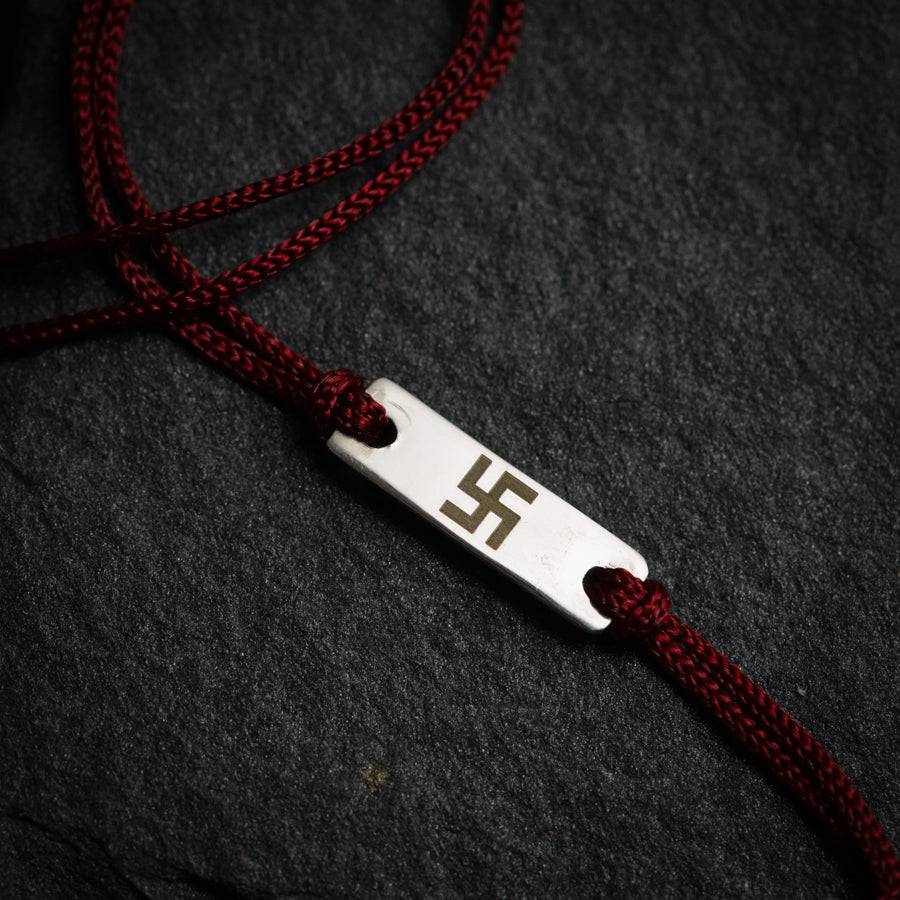 a red cord with a metal tag on it