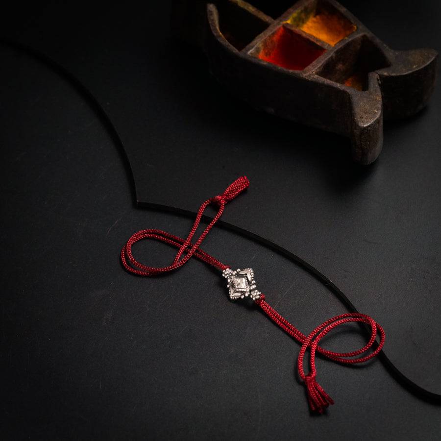 a red cord with a silver cross on it