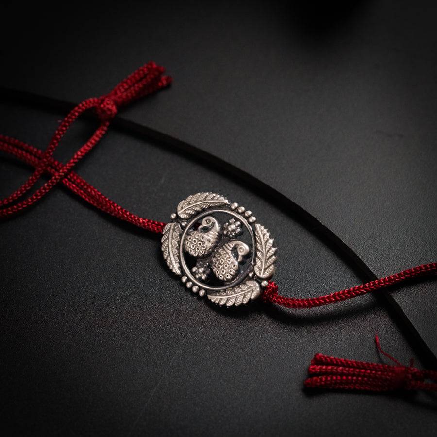 a close up of a red cord with a silver emblem on it