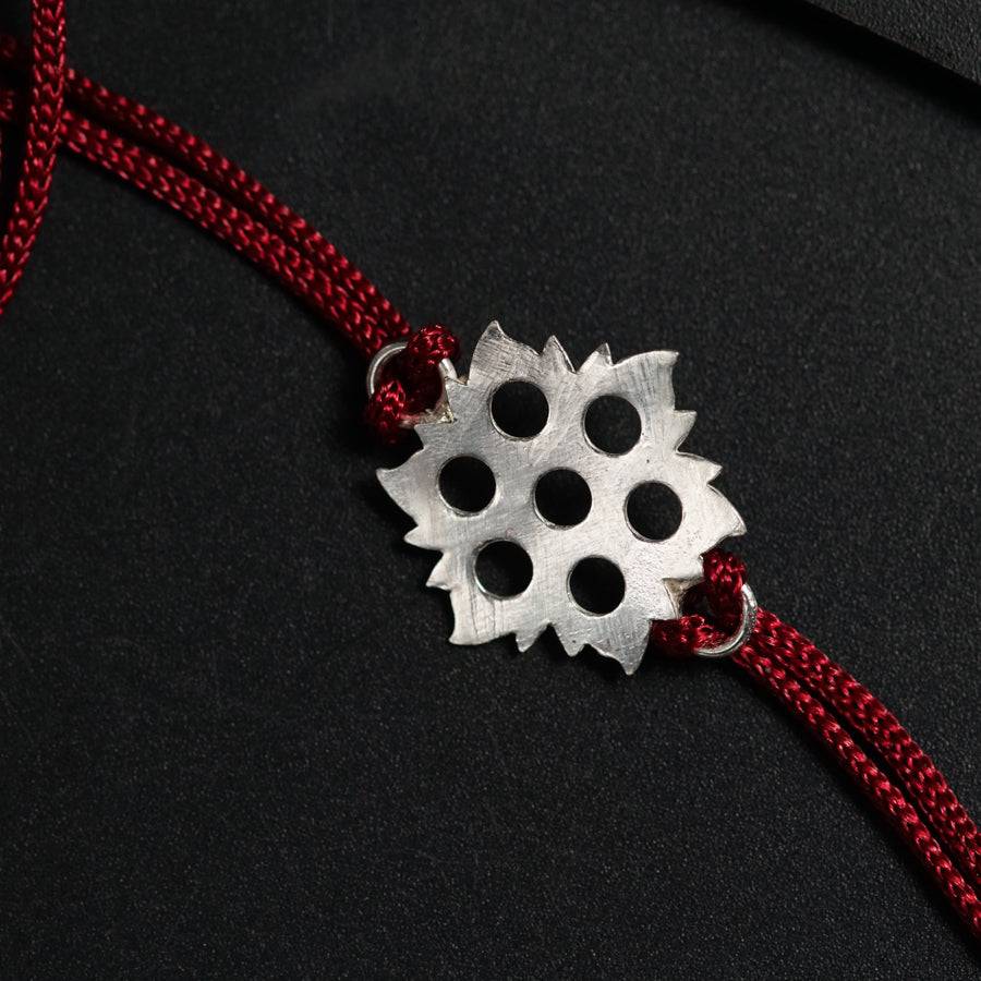 a red cord with a silver pendant on it