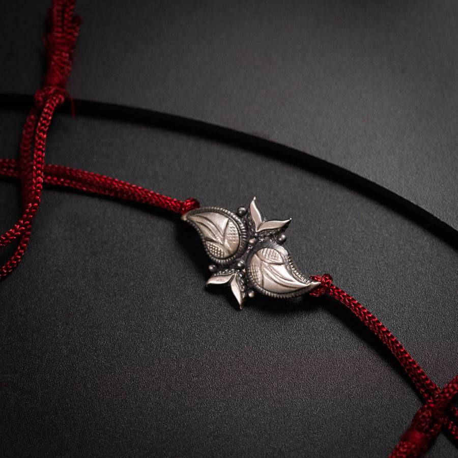 a red cord with a silver flower on it