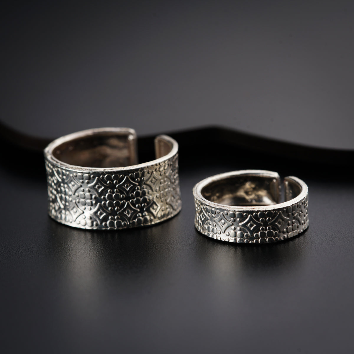 a pair of silver rings sitting on top of a table
