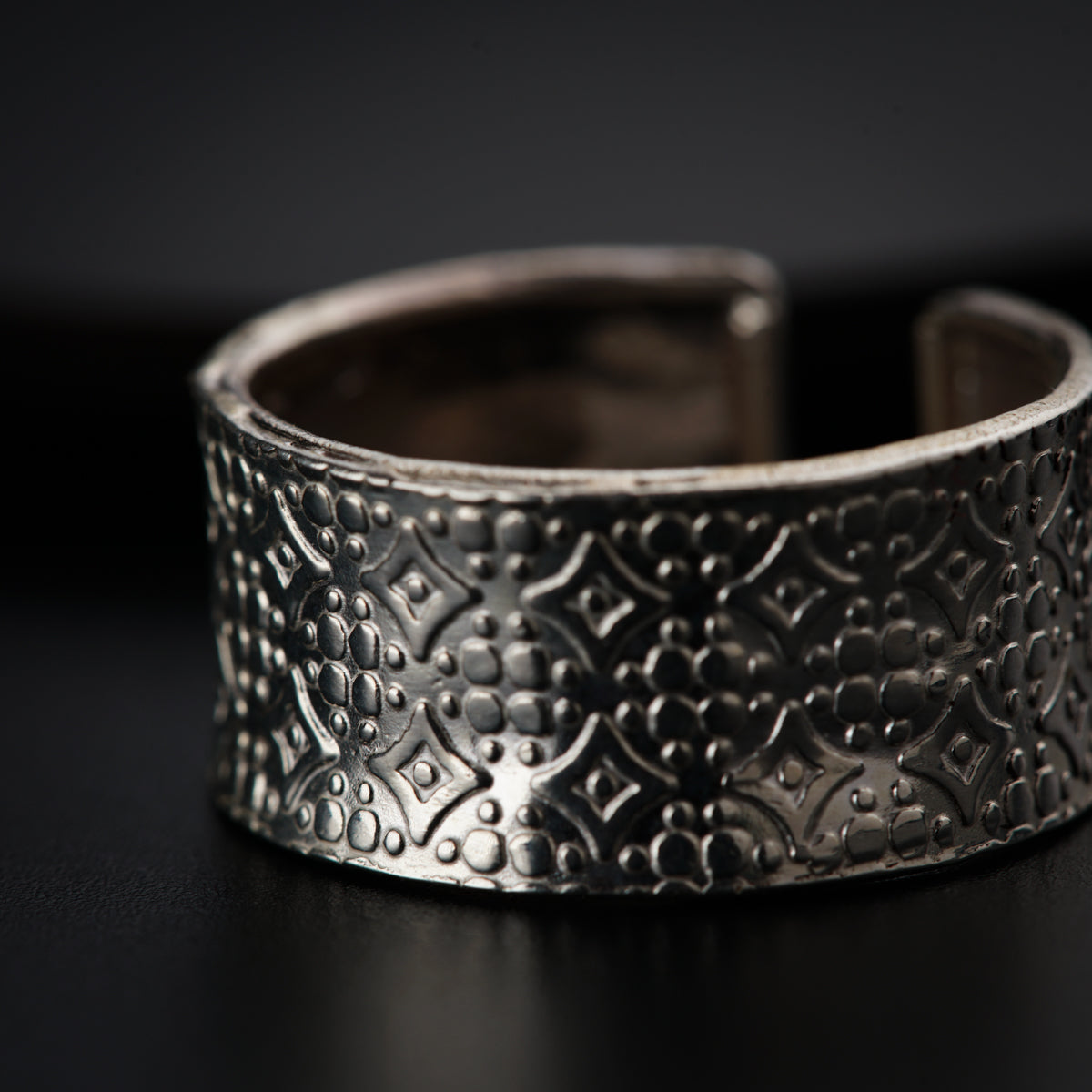 a close up of a silver bracelet on a table
