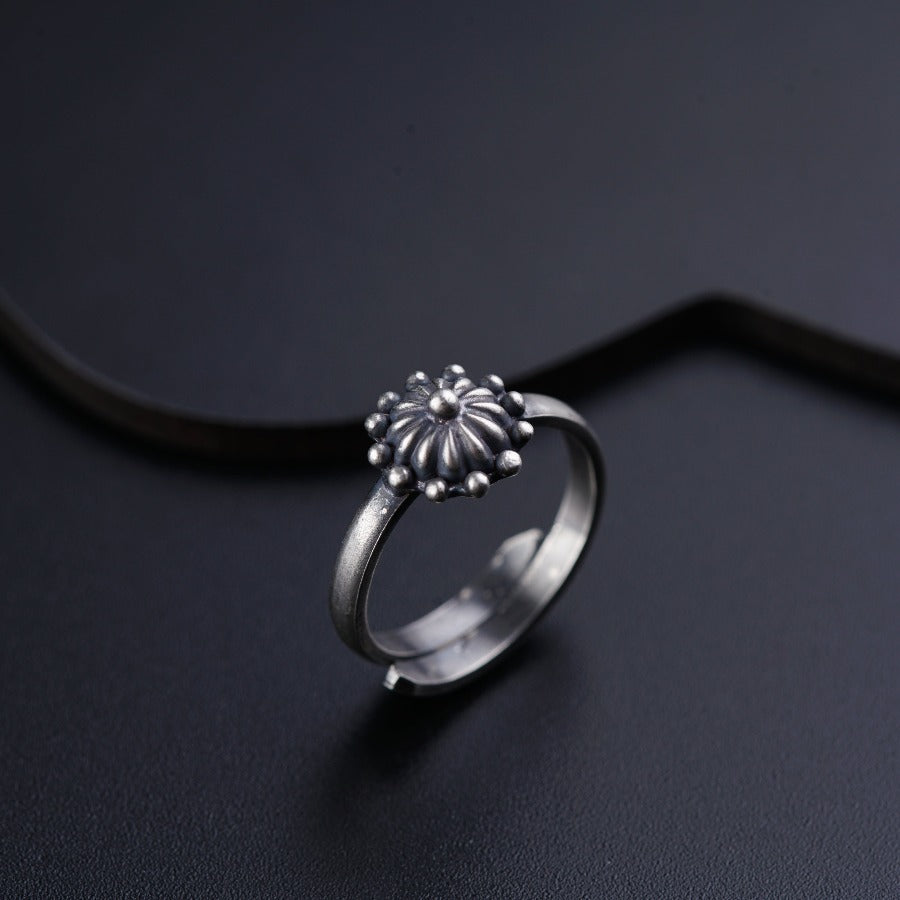 a silver ring with a flower on it