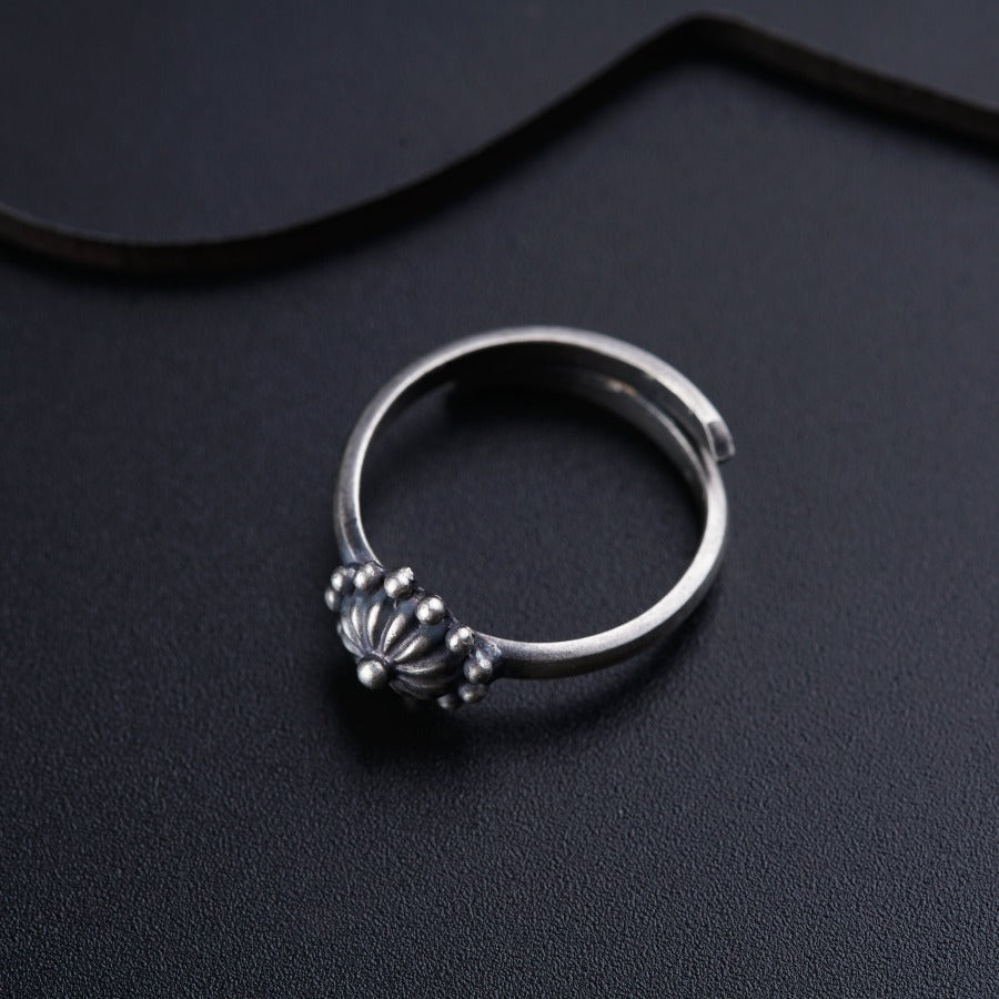 a silver ring sitting on top of a black surface