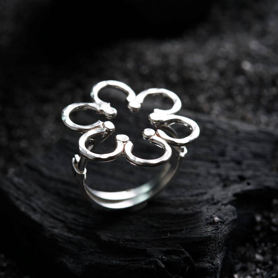 a silver ring sitting on top of a piece of wood