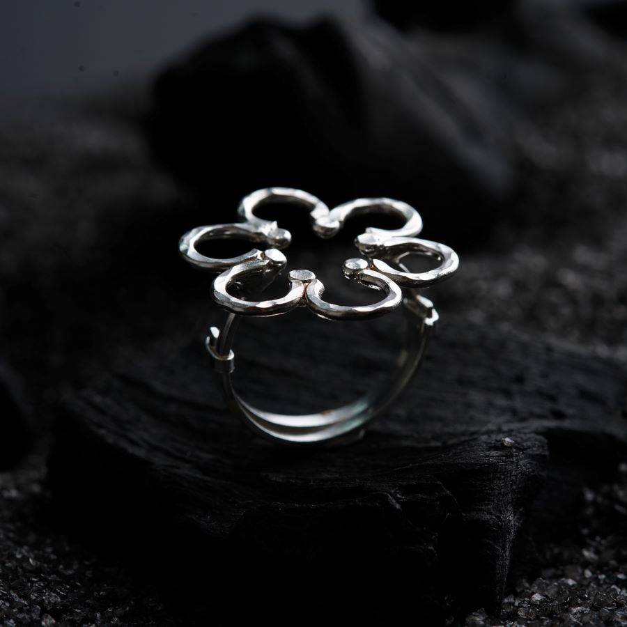 a silver ring sitting on top of a black cloth