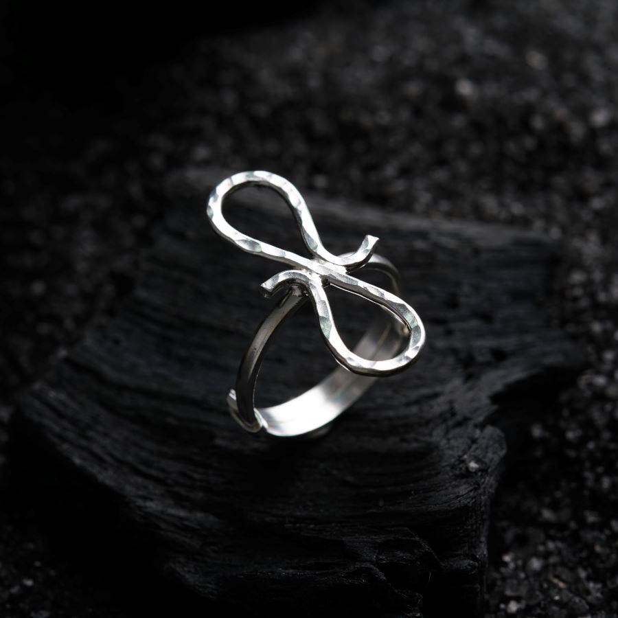 a silver ring sitting on top of a black surface