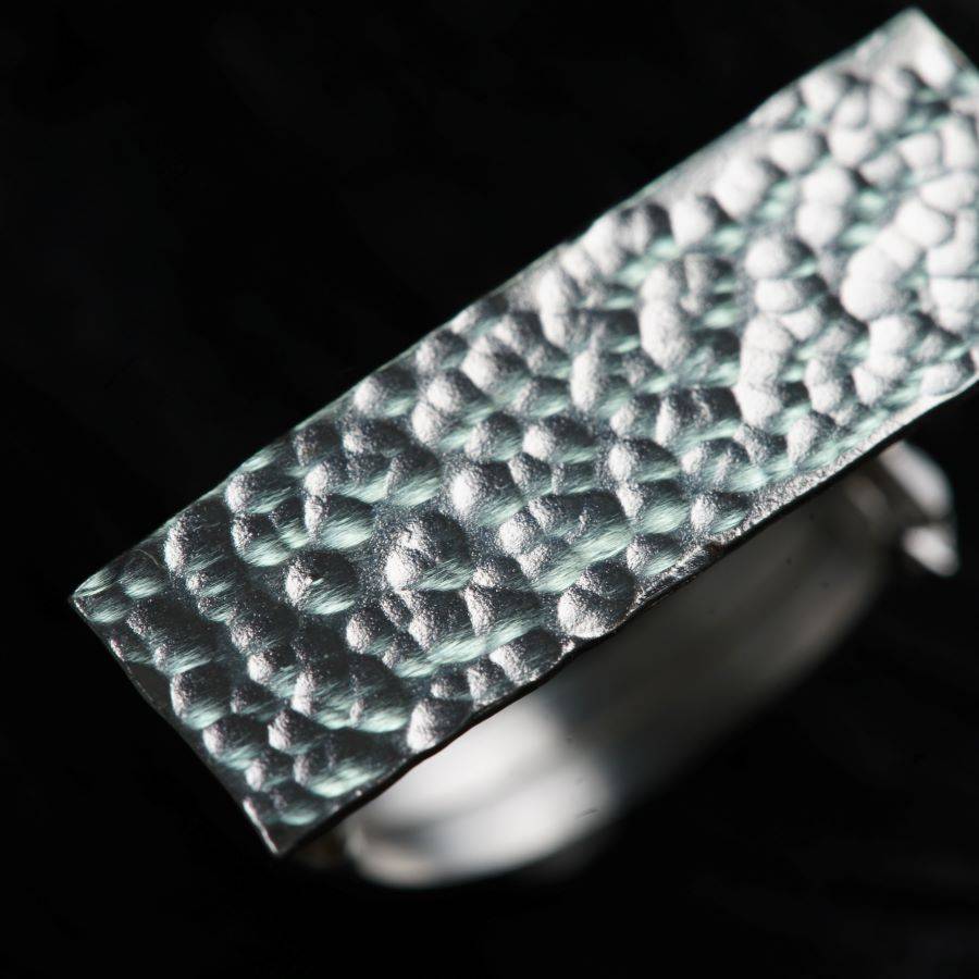a close up of a silver ring on a black background