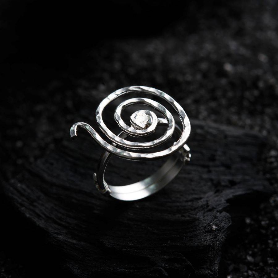a silver ring sitting on top of a black surface