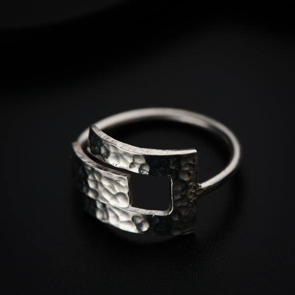 a close up of a silver ring on a black surface