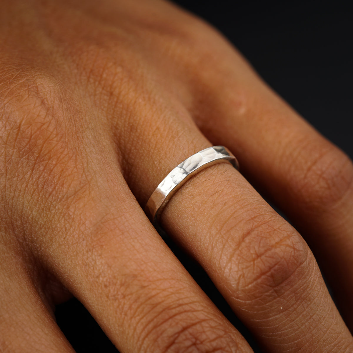 a person's hand with a wedding ring on it