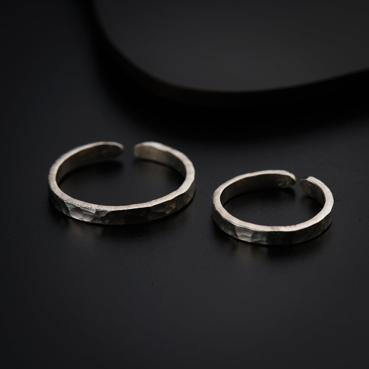 a pair of silver rings sitting on top of a table