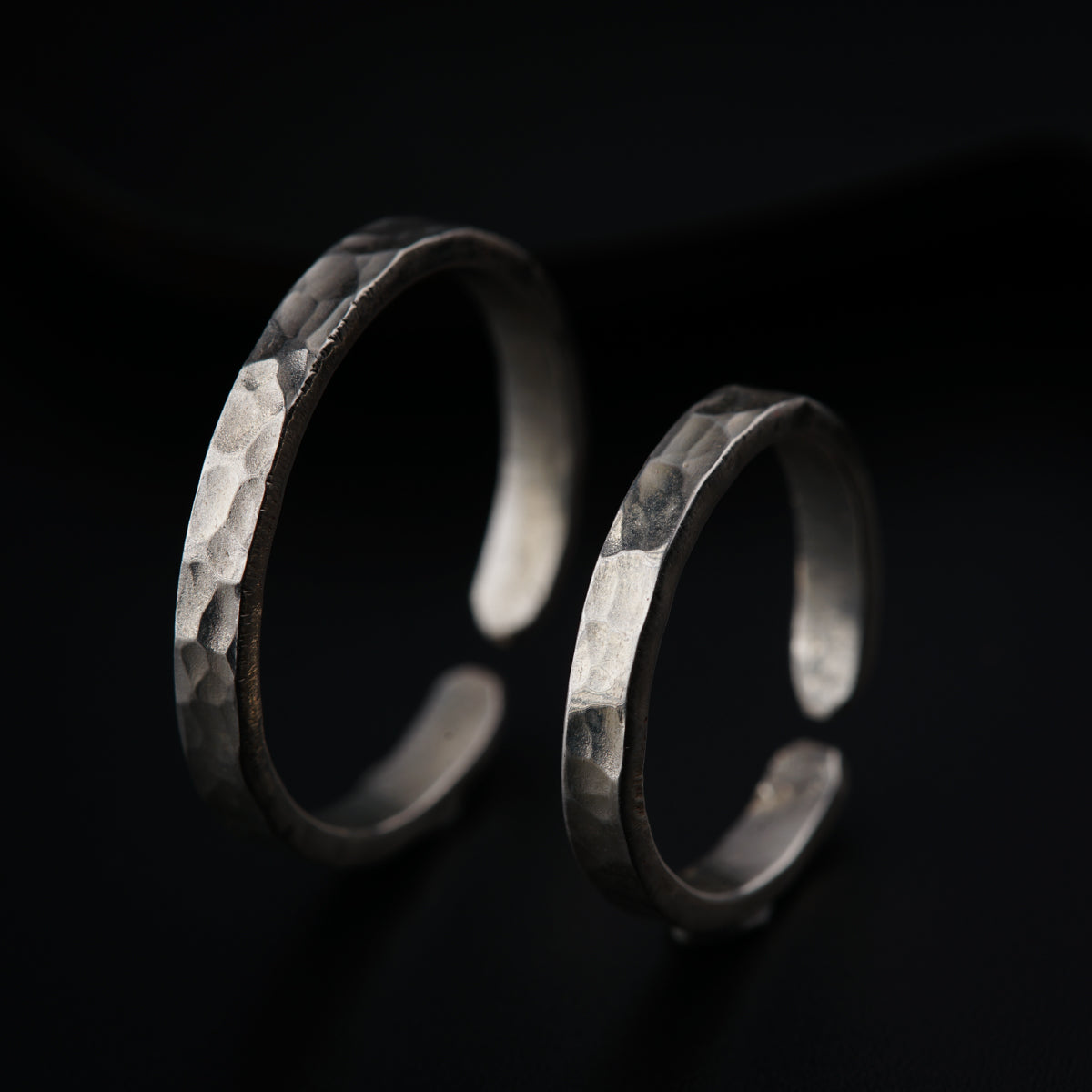 a pair of silver rings sitting on top of a table