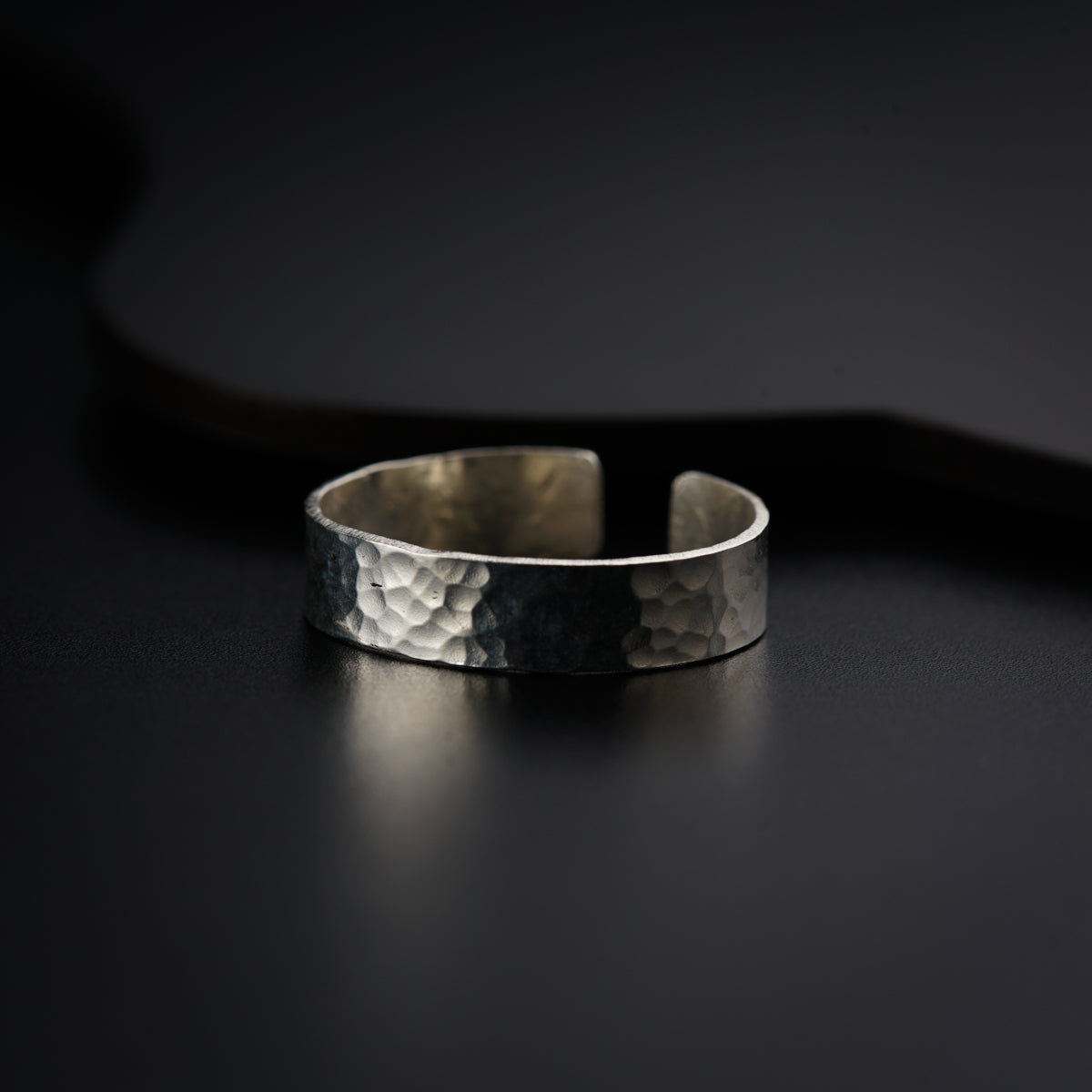 a close up of a silver ring on a black surface