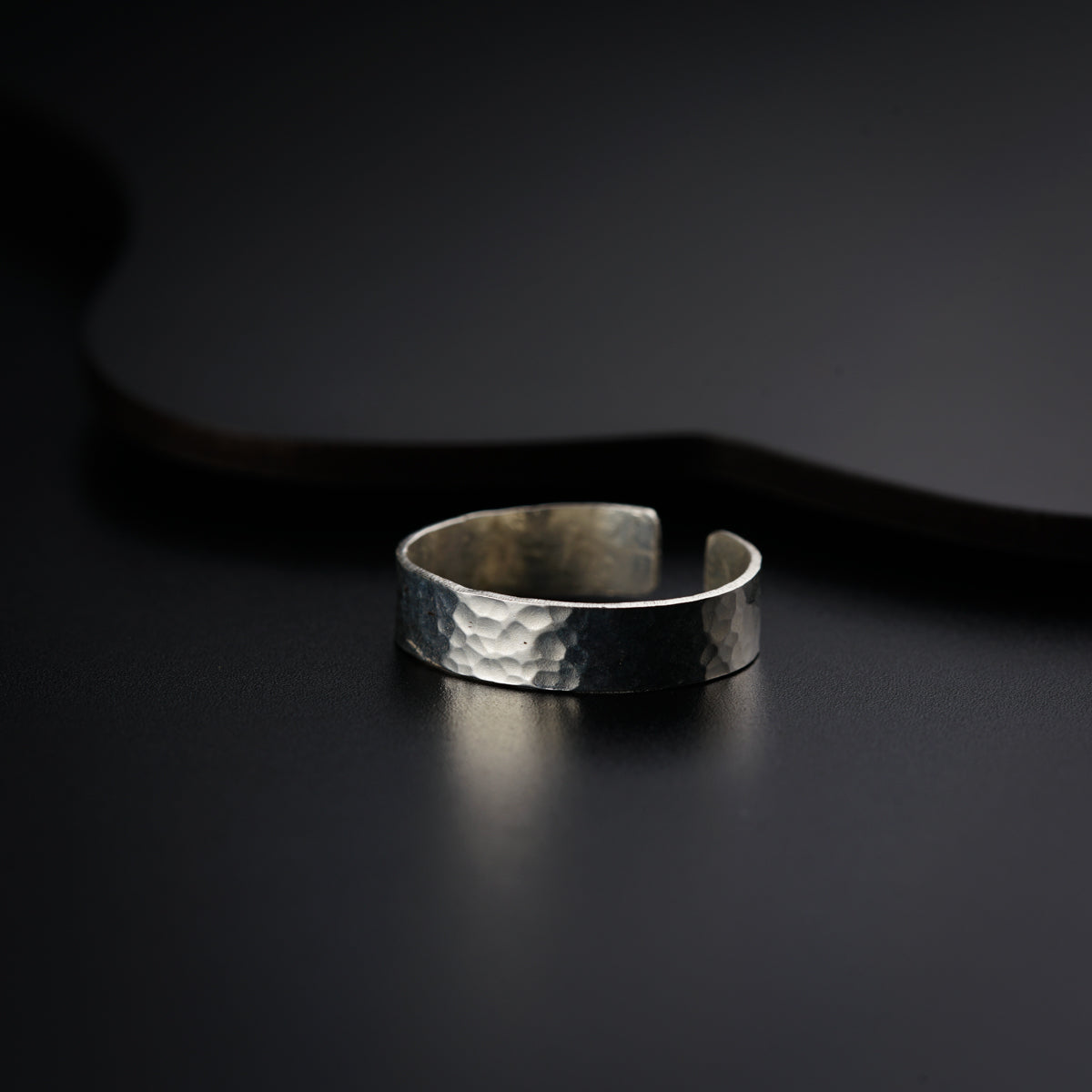 a close up of a silver ring on a black surface