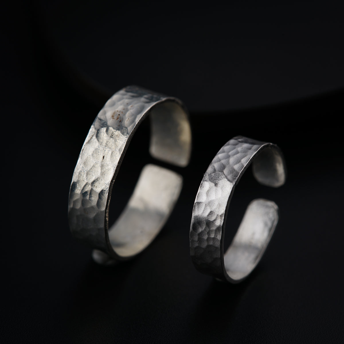 a pair of silver rings on a black background