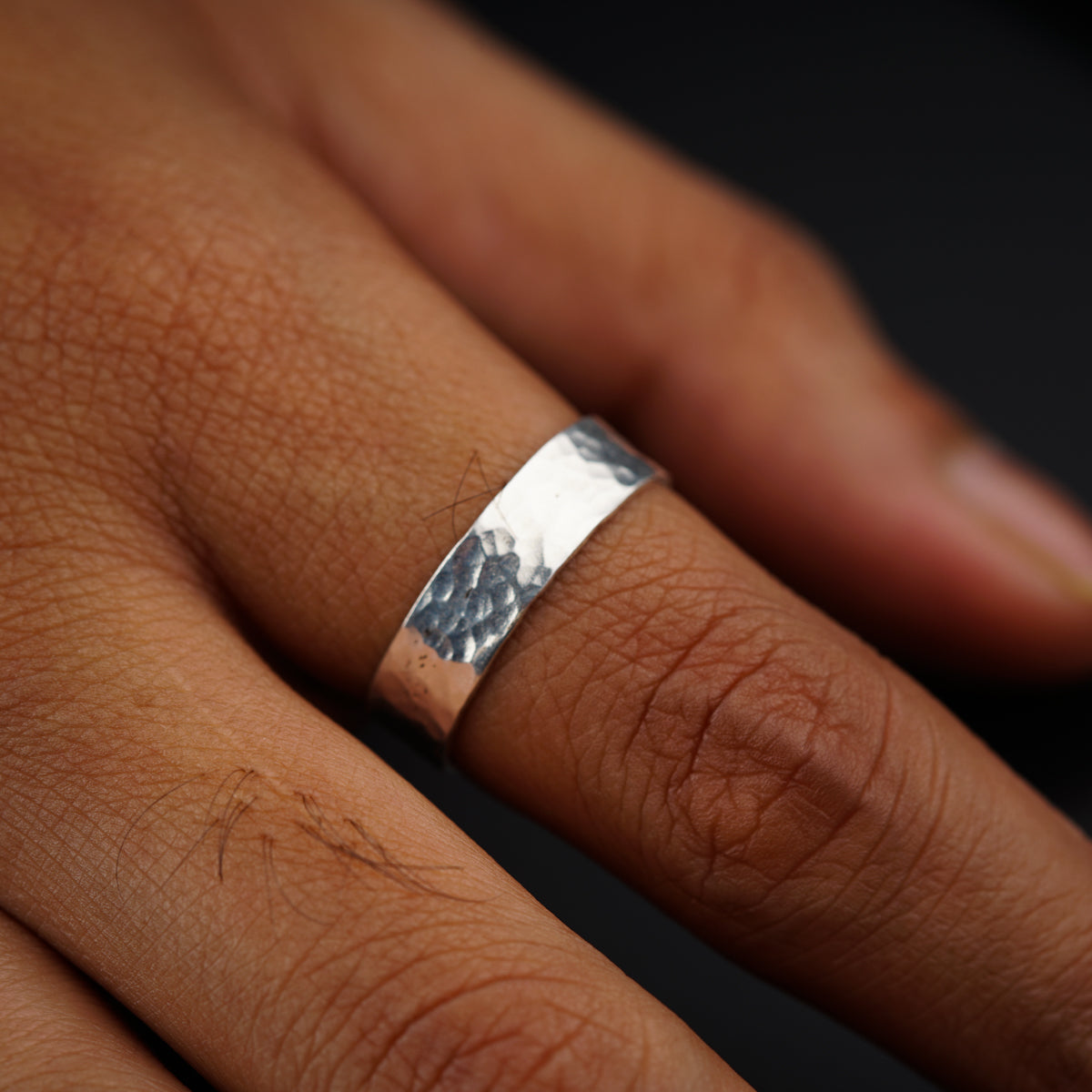 a close up of a person's hand with a ring on it